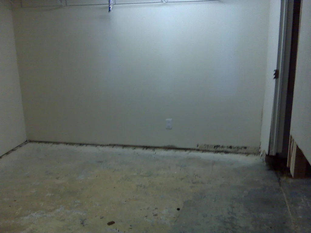 Basement room with a water-stained concrete floor