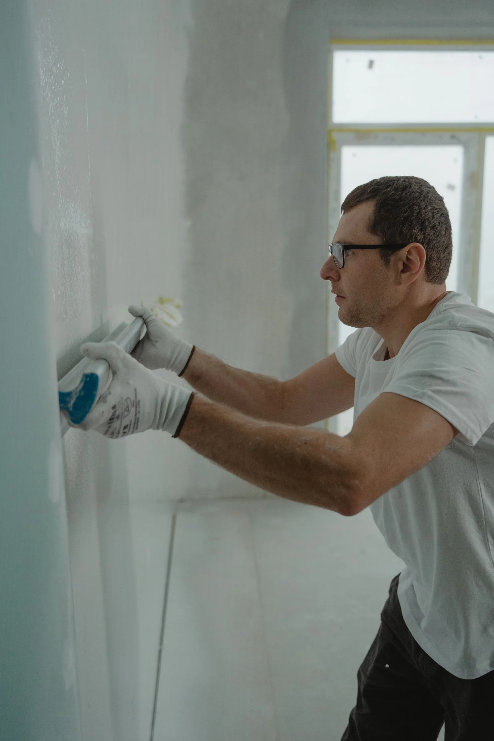 Worker applying drywall compound during a home renovation