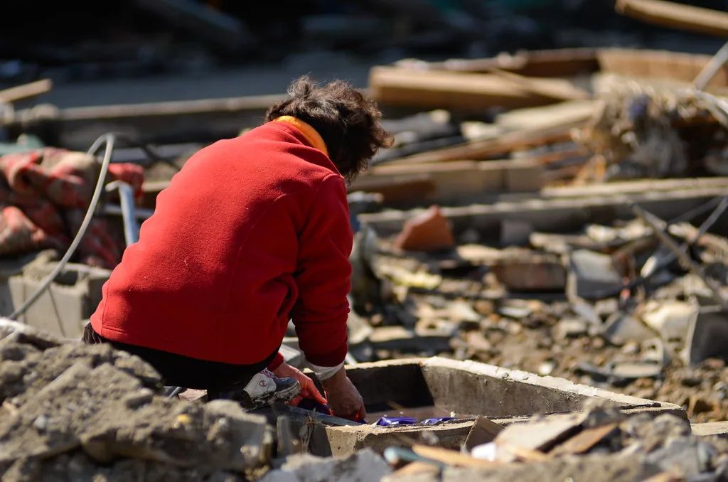 Volunteer sorting through flood debris